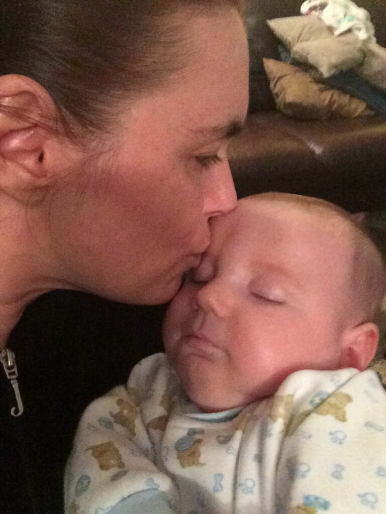 Momma kissing an infant Charlie