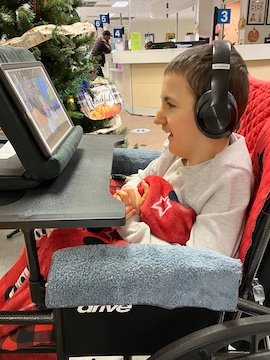 Charlie Karrat with headphones waiting for his appointment at a doctor's office.