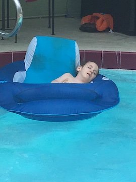 Charlie Karrat passed out in a floatie in a pool.